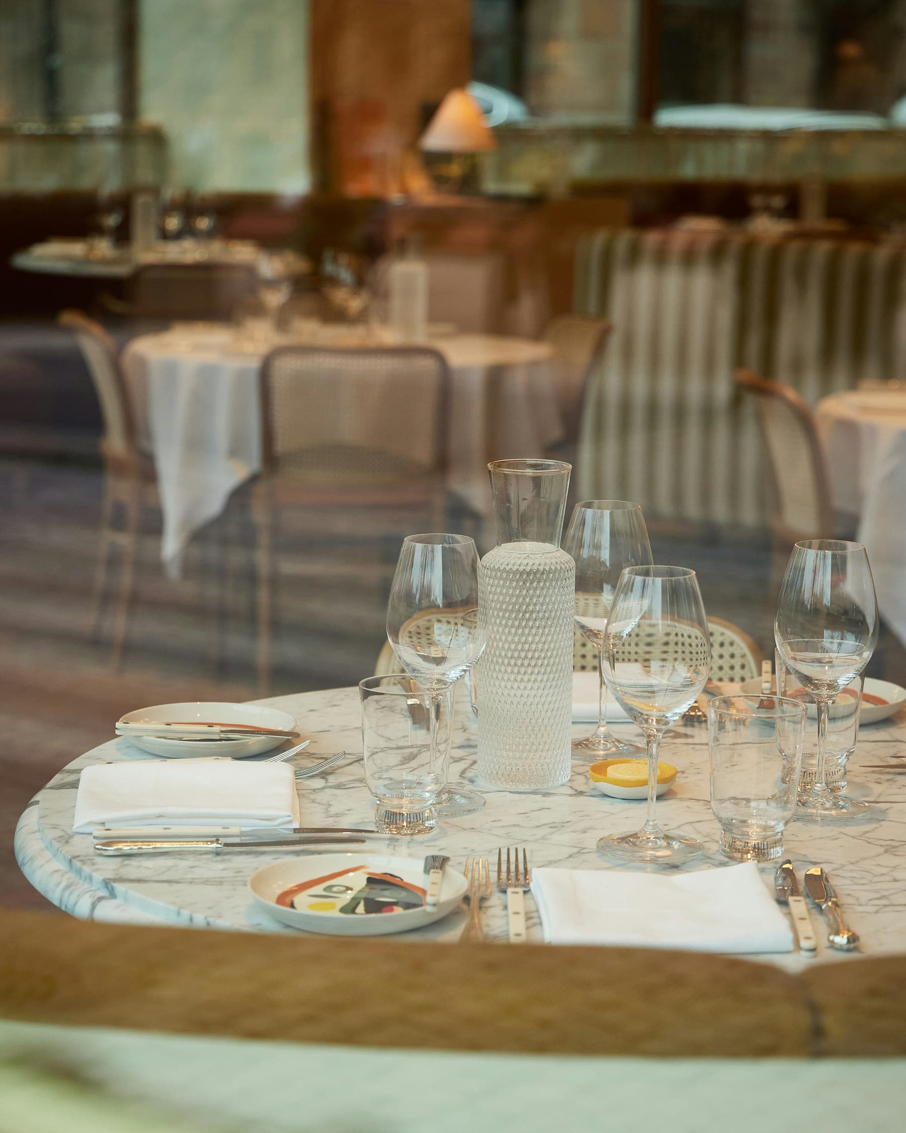 Laid tables with glassware and white linen in the dining room